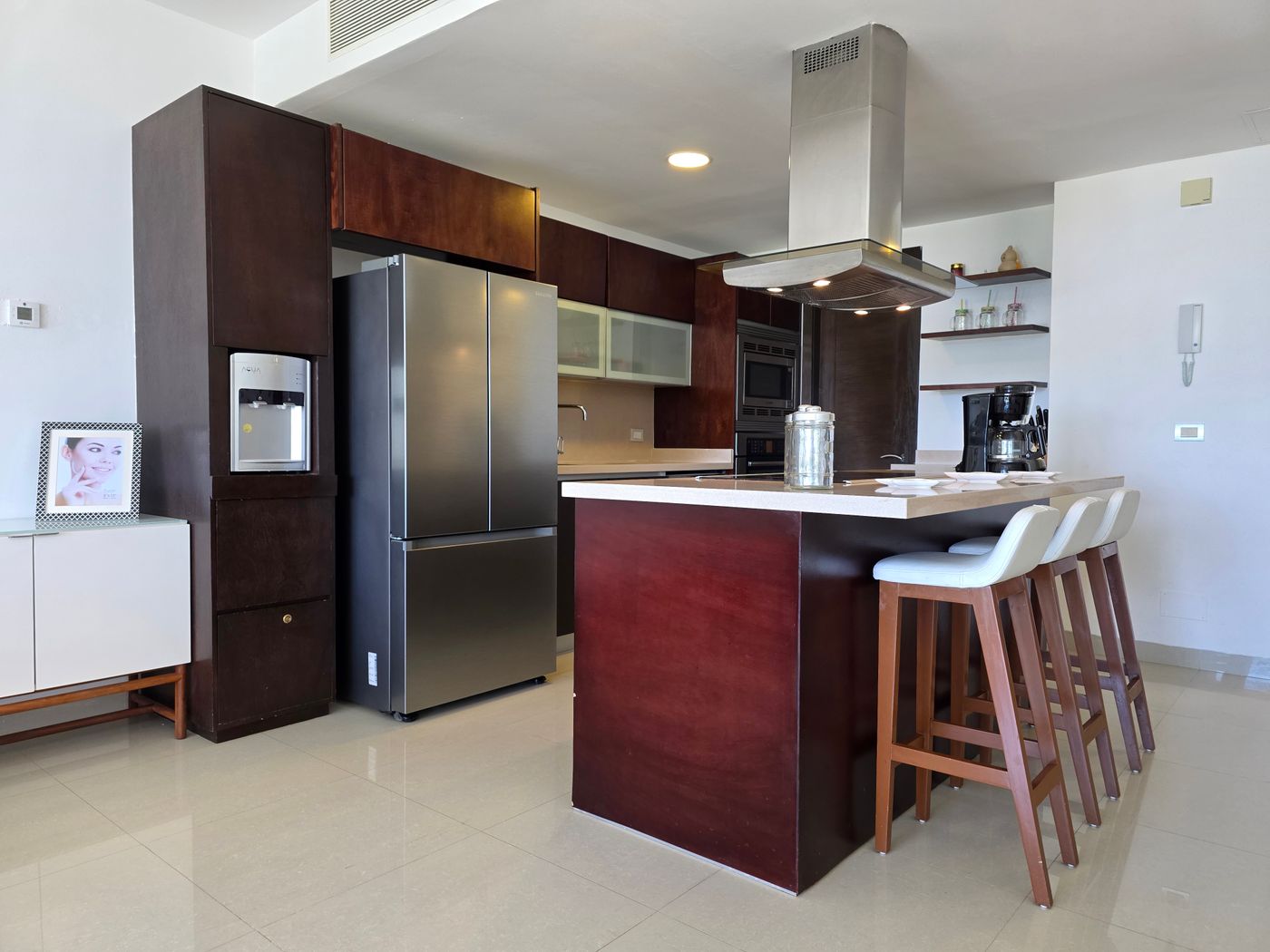 Kitchen peninsula with stools and dark wood cabinetry